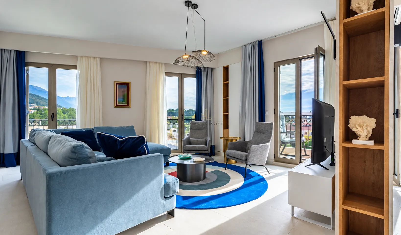 Spacious living room with a sofa, armchairs, and access to the terrace.