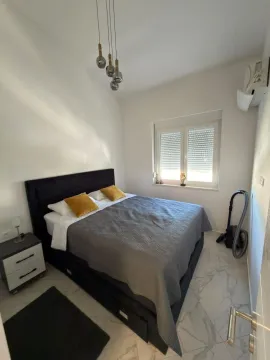Furnished bedroom with a double bed, nightstand, and a window. - image 4