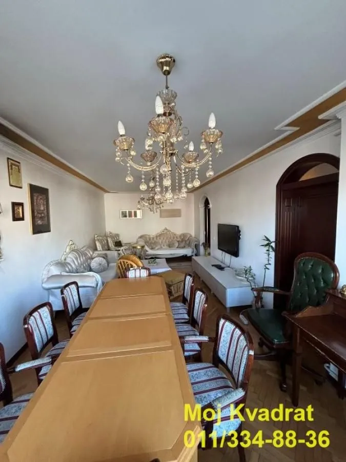 Prostrana dnevna soba sa trpezarijskim stolom i garniturom za sedenje.