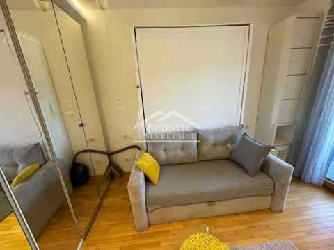 Small living room with a sofa and a built-in mirrored wardrobe. - image 10