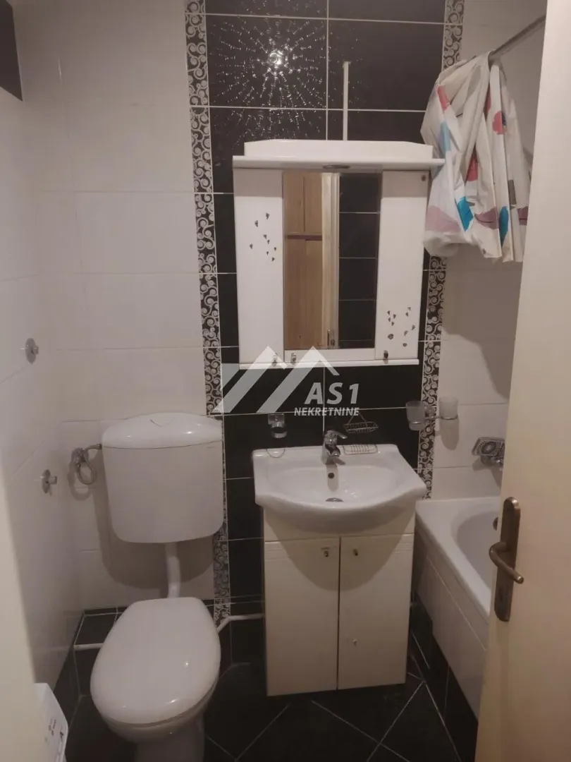 Manje kupatilo sa umivaonikom, WC šoljom i kadom.