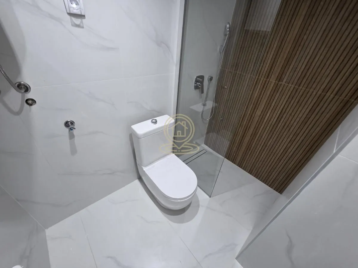Savremeno opremljeno kupatilo sa tuš kabinom i wc šoljom.