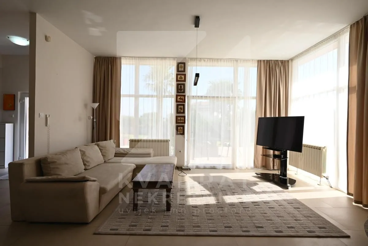 Spacious living room with a seating set and large windows.