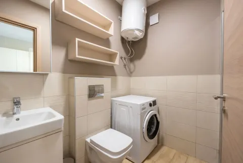 Modernly equipped bathroom with a washing machine and built-in water heater. - image 8