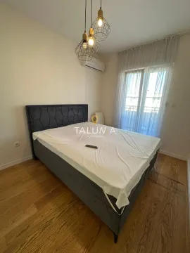 Spavaća soba sa bračnim krevetom i drvenim podom. - image 7