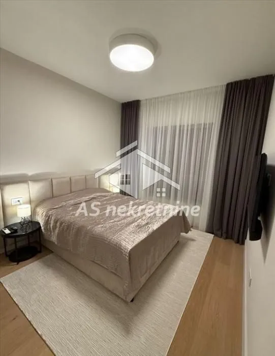 Modern bedroom with a double bed, rug and curtains.