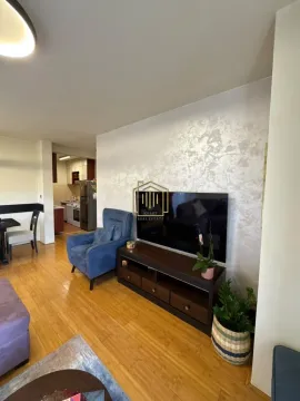 Pogled na dnevnu sobu sa televizorom, foteljom i trpezarijom u pozadini. - image 3