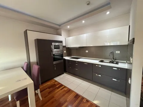Modern kitchen with built-in appliances and a dining table. - image 2