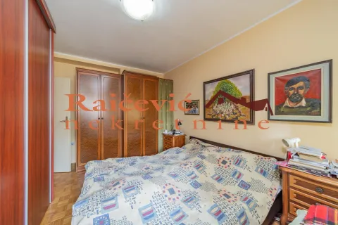 Nameštena spavaća soba sa bračnim krevetom, drvenim ormarima i umetničkim slikama na zidu. - image 15