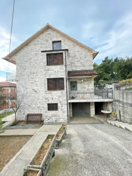Exterior view of a multi-story stone house with a garage and paved yard. - image 5
