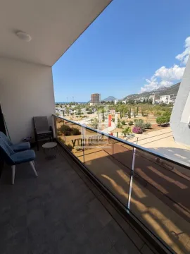 Covered balcony with a glass railing and seating furniture, overlooking the surroundings. - image 7