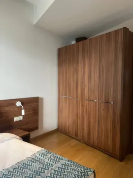 A bedroom with a large wooden wardrobe and a bed. - image 5