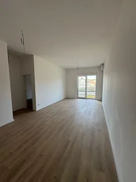 Prazna neopremljena prostorija sa drvenim podom i balkonskim vratima. - image 4
