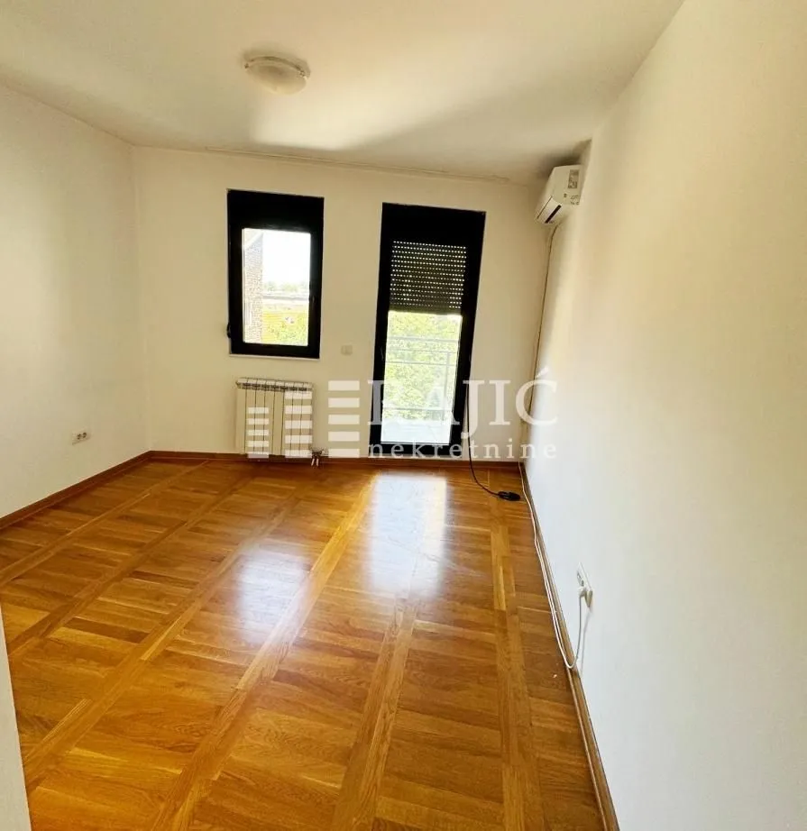 Empty room with parquet flooring and white walls.