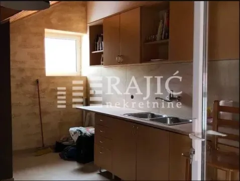 Smaller kitchen with wooden cabinets and a sink. - image 8