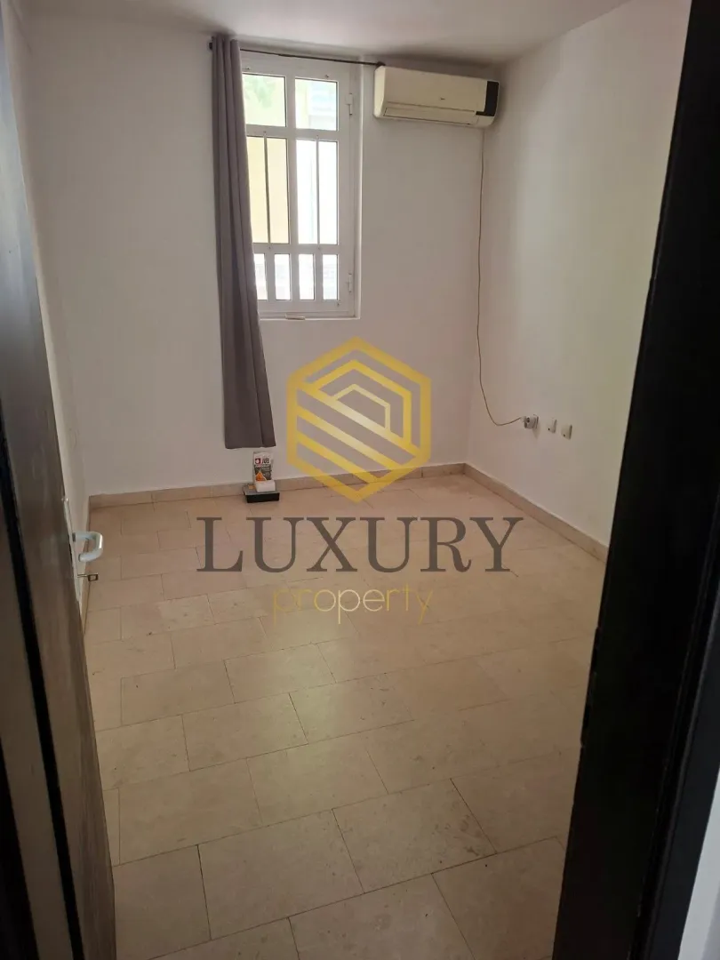 Empty room with floor tiles and an air conditioning unit on the wall.