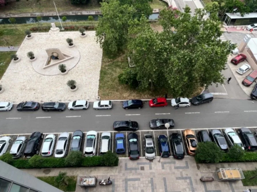 Pogled sa terase na parking i okolno zelenilo.