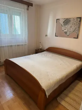Spavaća soba sa bračnim krevetom, prozorom i umetničkom slikom na zidu. - image 15