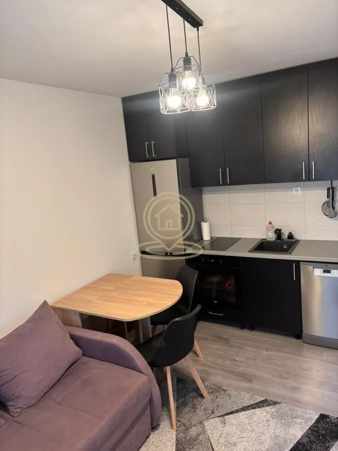 Small kitchen with a dining table and a sofa.