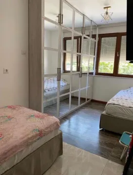 Namještena spavaća soba sa velikim oglednim ormarom i dva kreveta. - image 13