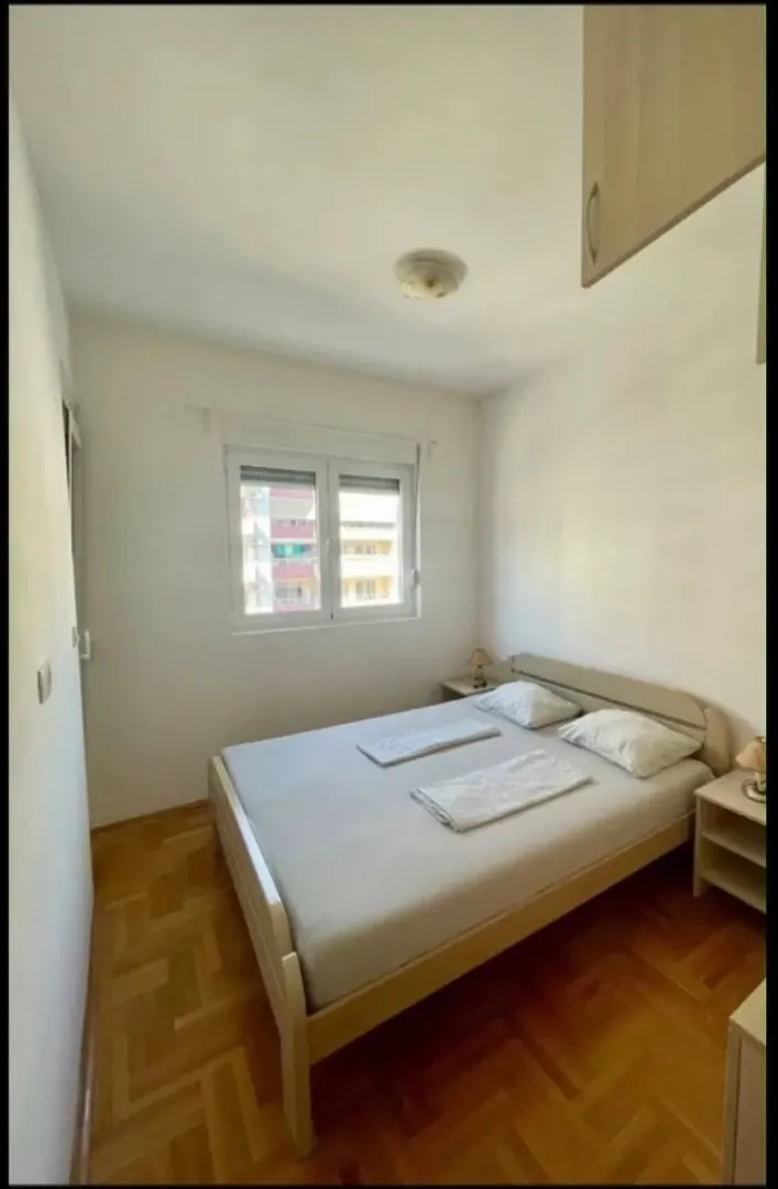 Furnished bedroom with a double bed and a window.