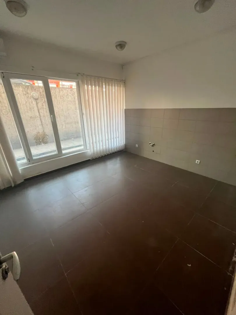 Empty room intended for a kitchen with ceramic tiles on the floor and walls.