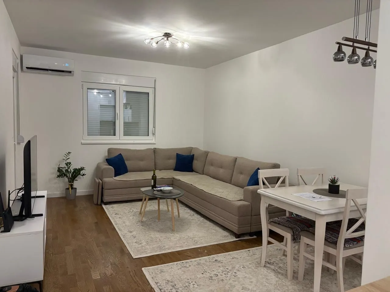 Spacious and bright living room with a sofa and dining table.