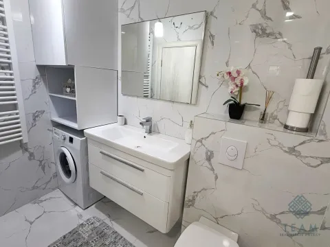 Moderno opremljeno kupatilo sa umivaonikom, ogledalom i veš mašinom. - image 12