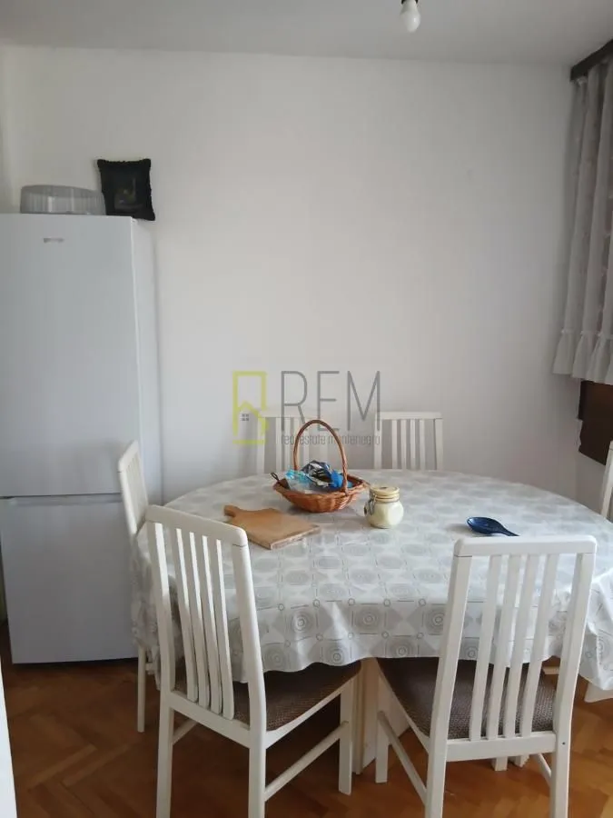 Dining area with a table, chairs, and a refrigerator.