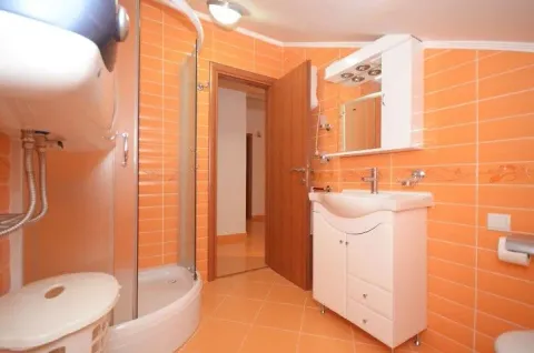 Svijetlo kupatilo sa narandžastim pločicama i tuš kabinom. - image 11