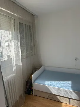 Children's bedroom with a bed and a window with white curtains. - image 5