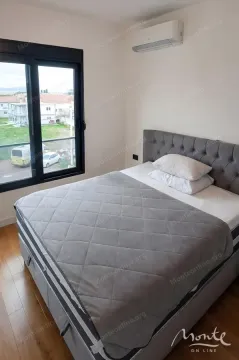 Bedroom with a double bed, air conditioning unit, and a window overlooking the neighborhood. - image 6