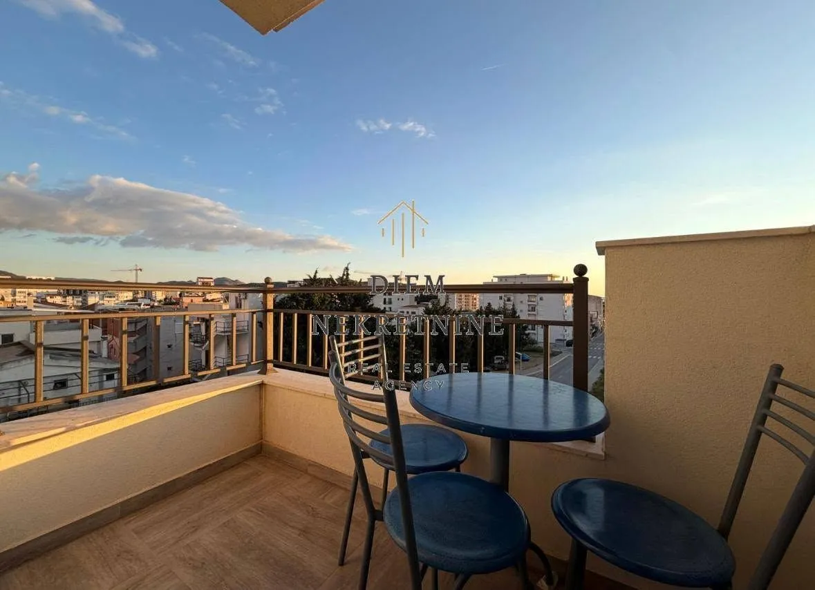 Furnished terrace with a table and chairs and a city view.