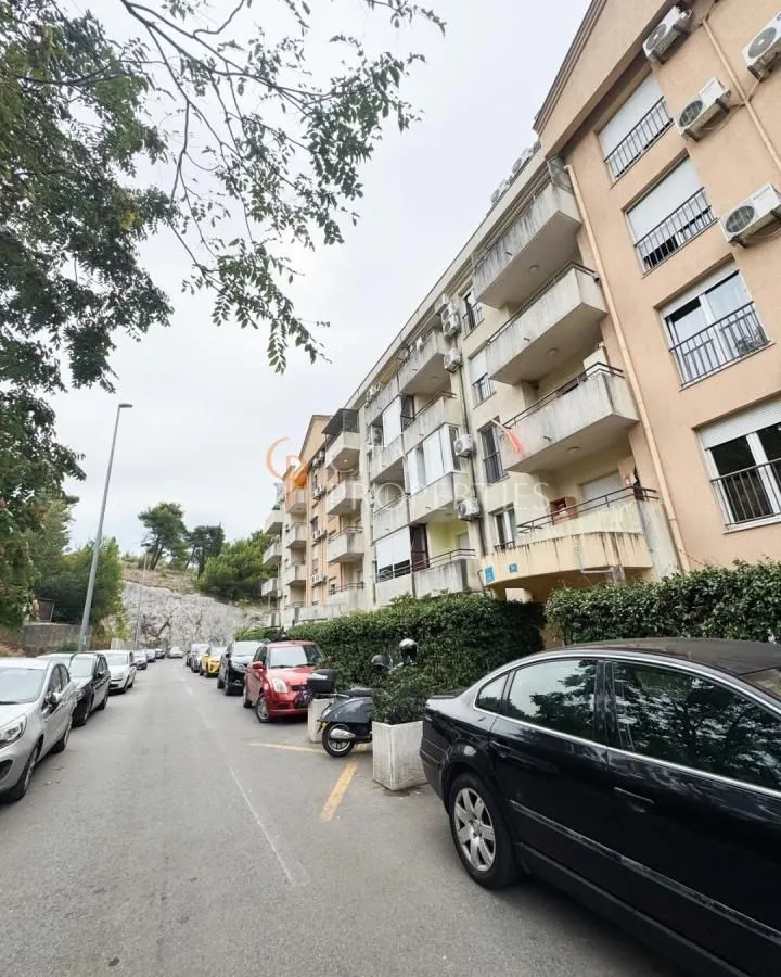 View of the exterior of the residential building and parking in front of the entrance.