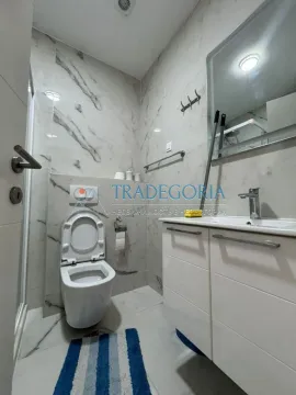 Manje kupatilo sa bijelim pločicama, umivaonikom i wc šoljom. - image 11