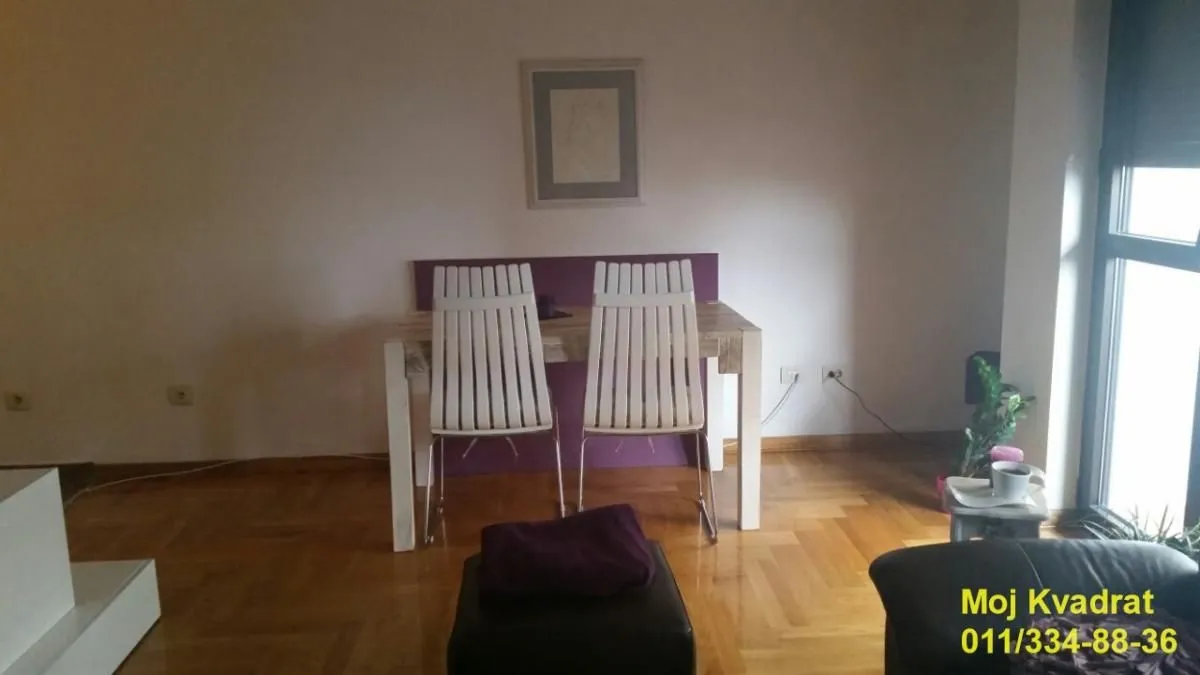 Dnevni boravak sa trpezarijskim stolom i stolicama.