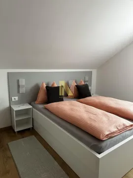A furnished bedroom with a double bed and a nightstand. - image 16