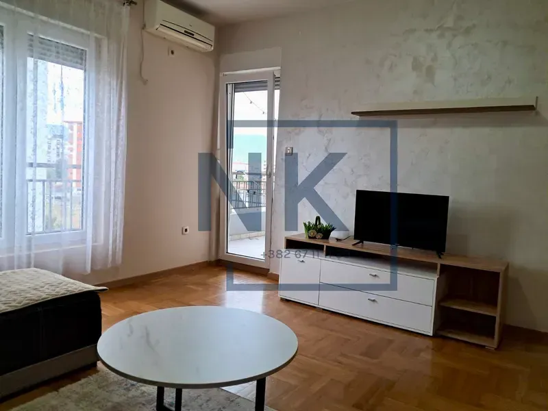 Living room with a TV unit, coffee table, and access to the terrace.
