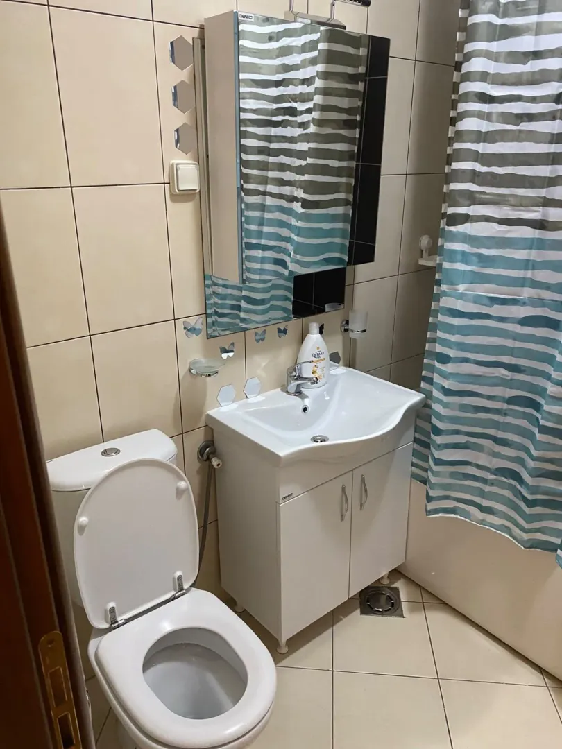 Manje kupatilo sa umivaonikom, WC šoljom i tuš kabinom.