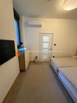 Nameštena spavaća soba sa bračnim krevetom, klima uređajem i TV-om. - image 14
