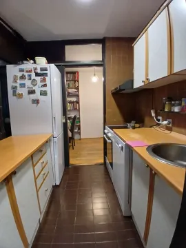 Kuhinja sa bijelim elementima, drvenim radnim površinama i frižiderom. - image 5