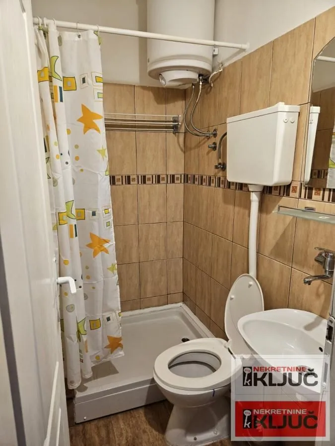 Manje kupatilo sa tuš kabinom, WC šoljom i umivaonikom.