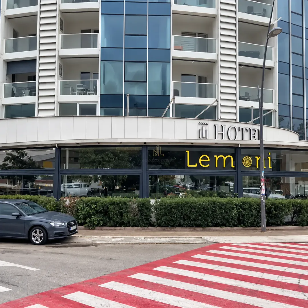 Exterior view of a modern hotel building with commercial space on the ground floor.