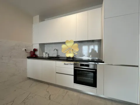 Modern white kitchen with built-in appliances and countertops. - image 6