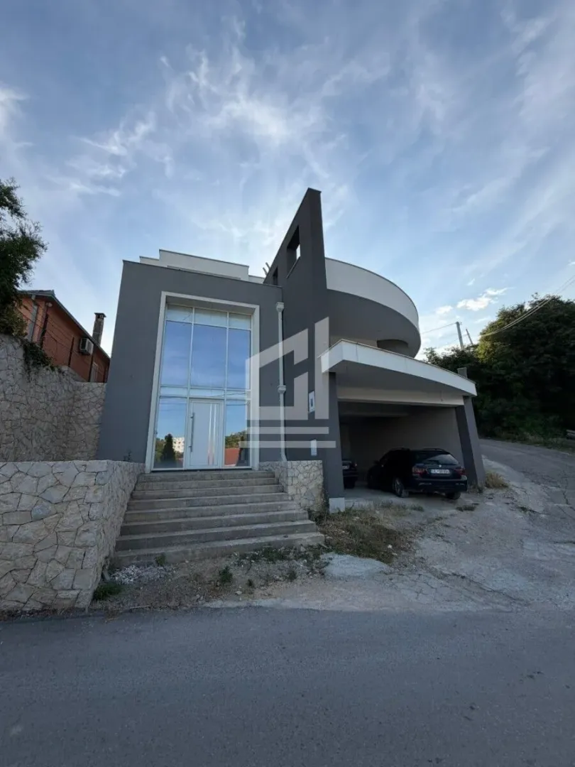 Eksterijer moderne dvospratne kuće sa garažom i stepeništem na ulazu.