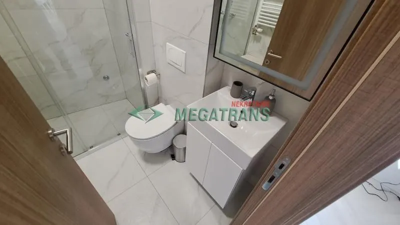 Moderno opremljeno kupatilo sa tuš kabinom, umivaonikom i WC šoljom.