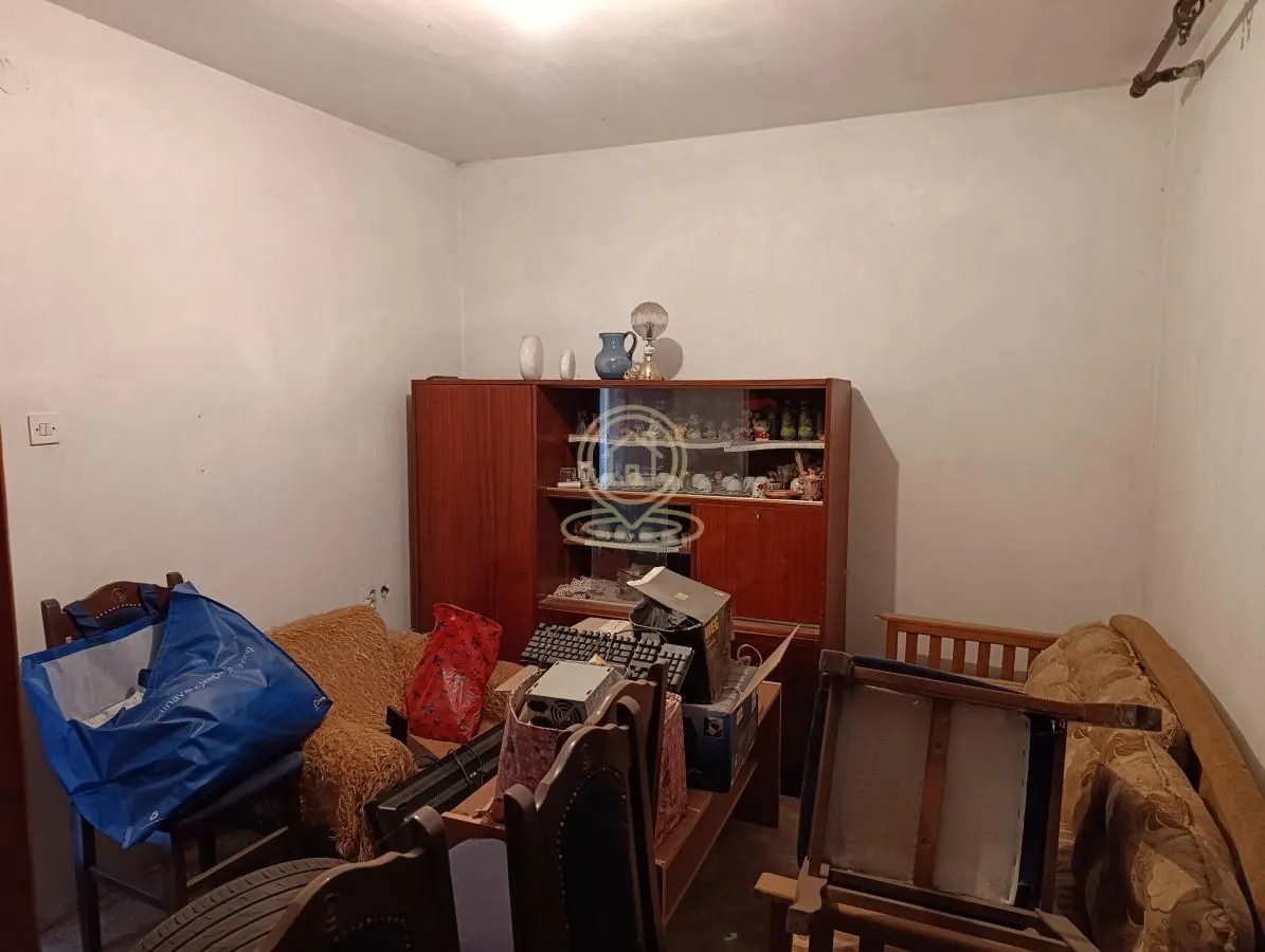 Dnevna soba sa nameštajem i starim ormarom.