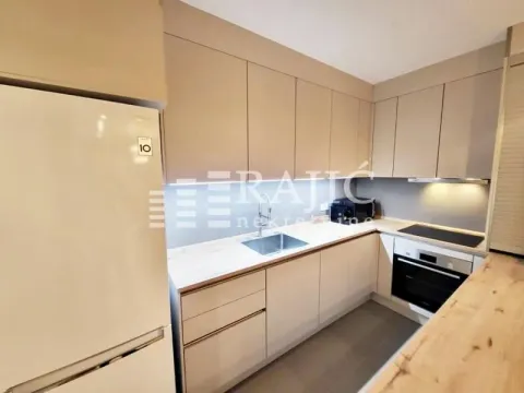 Modern kitchen with beige cabinets and built-in appliances. - image 4