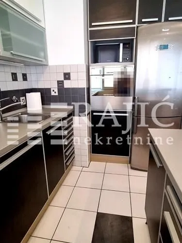 Modern kitchen with dark cabinetry and built-in appliances.