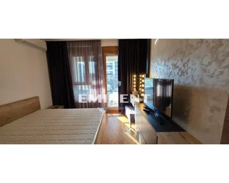 Furnished bedroom with a double bed, television, and balcony access. - image 9